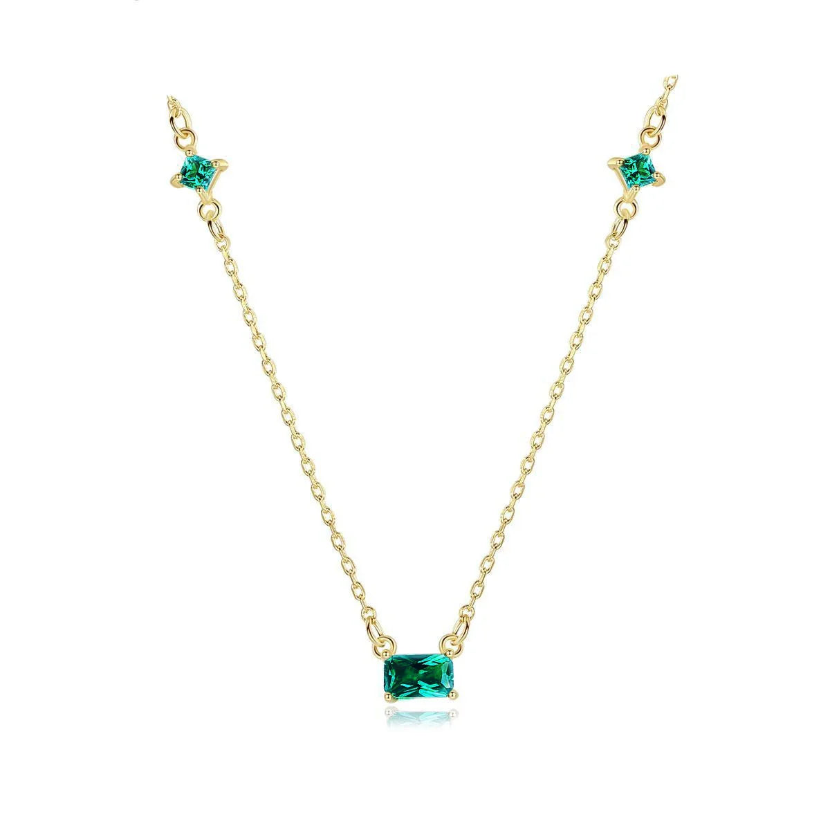 Collier doré avec pierre émeraude rectangulaire et deux petites pierres vertes, sur fond blanc. Idée cadeau femme. Koolkado.